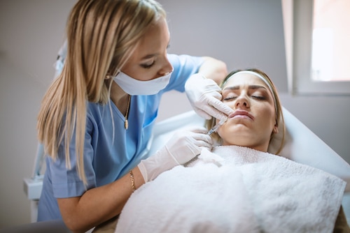 dermatologist providing lip fillers for a woman