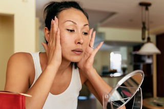 Woman tightening her skin in the mirror