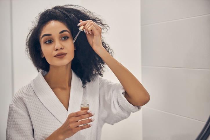 woman applying essential oils to her skin